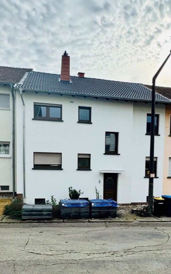 Reihenmittelhaus mit weißer Fassade und neu eingedecktem Dach